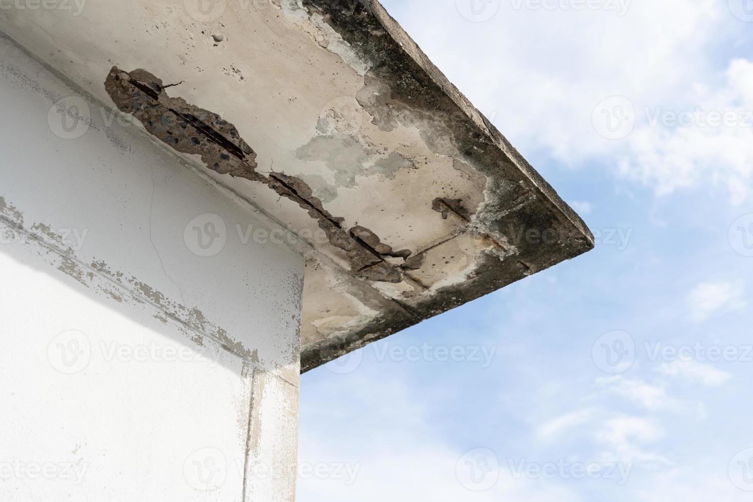 Water damaged ceiling roof in an old house. Water damage building interior. Ceiling house broken. Ceiling concrete crack and exposed the rusty steel bar frame. photo