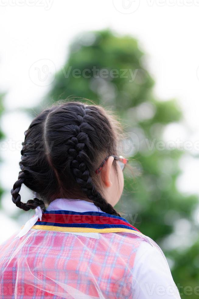 Vertical photos. Braided girl stood back and looked to the front. Children wearing graduation gowns in kindergarten. Girls 5-6 years old. photo