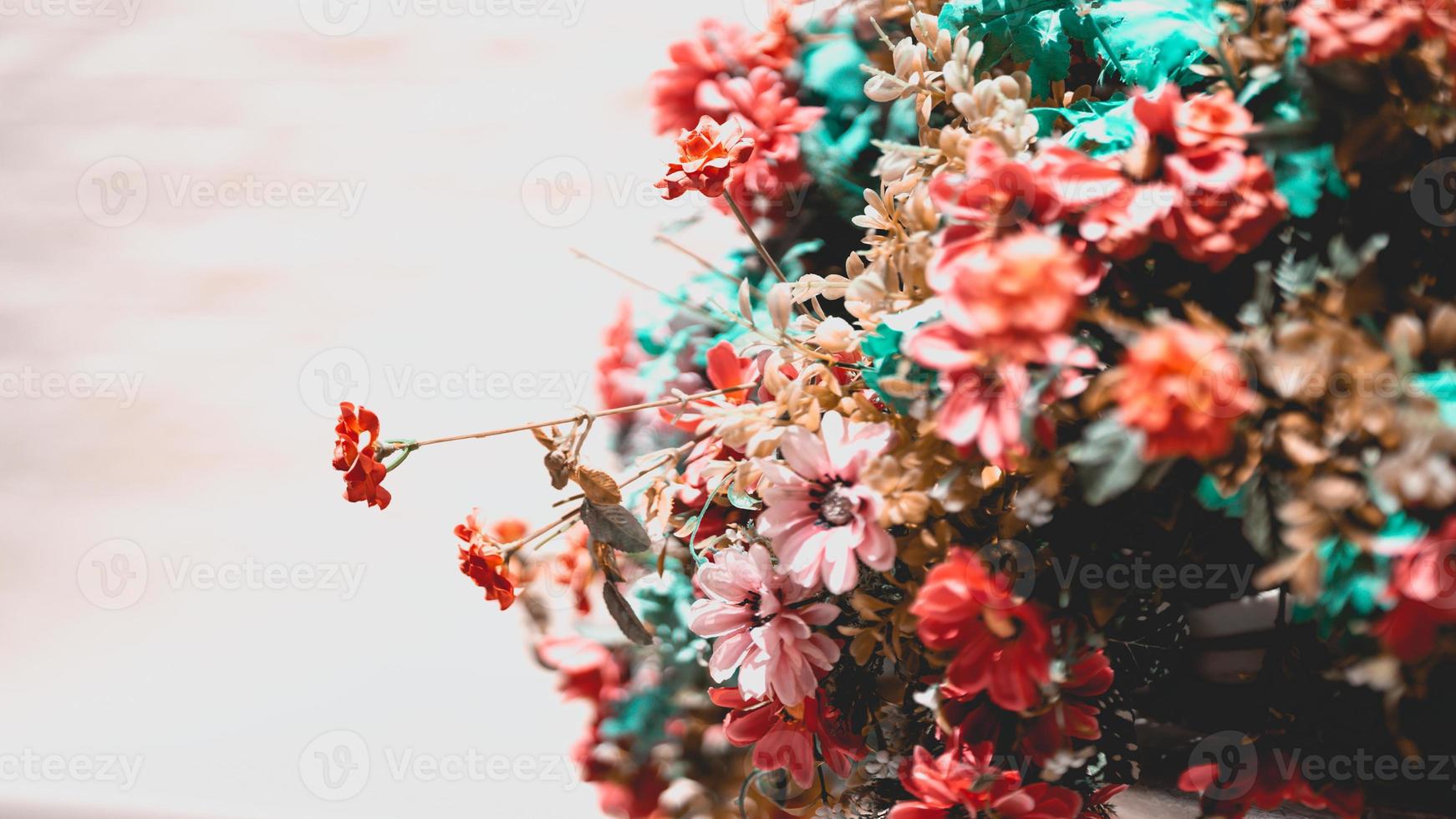 Abstract background of orange fake flower bushes to decorate the walkway. Old wall background. Empty space. photo