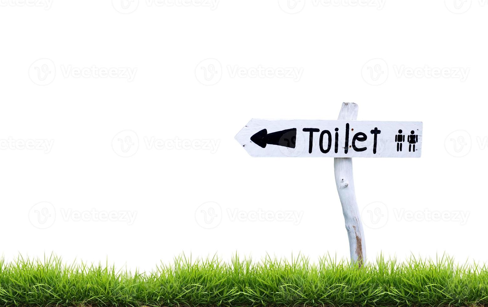 white wooden toilet sign with green grass photo