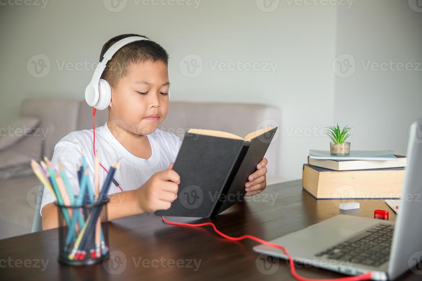 Young student distance learning virtual distance online class on video call virtual lesson, technology studying at home using laptop computer. Parent or tutor teaching child boy with remote education. photo