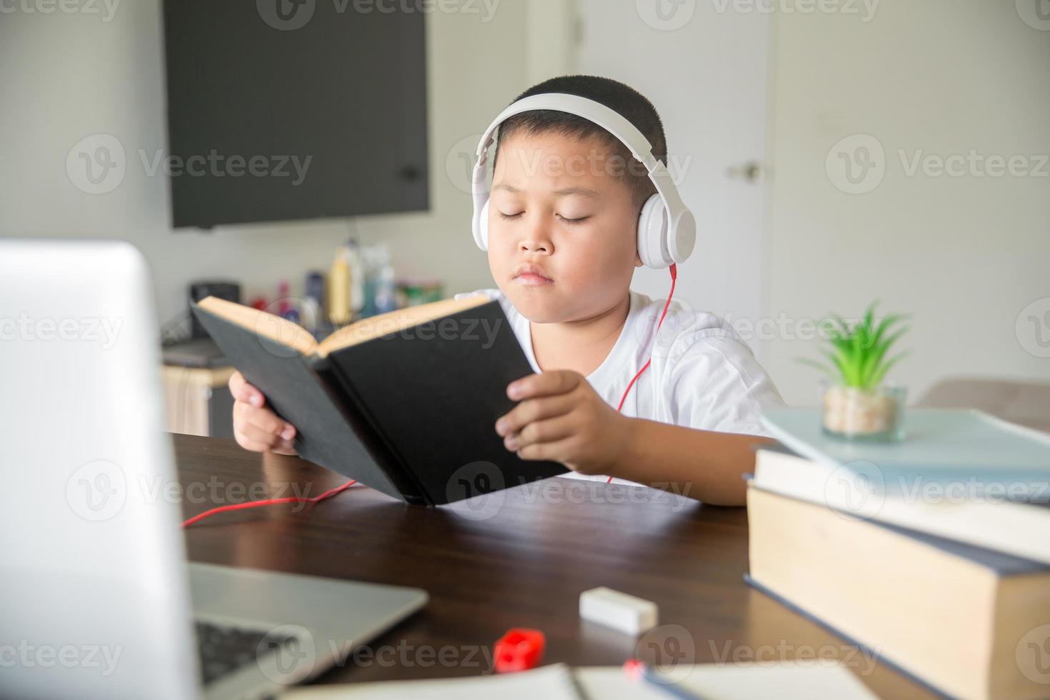 Young student distance learning virtual distance online class on video call virtual lesson, technology studying at home using laptop computer. Parent or tutor teaching child boy with remote education. photo