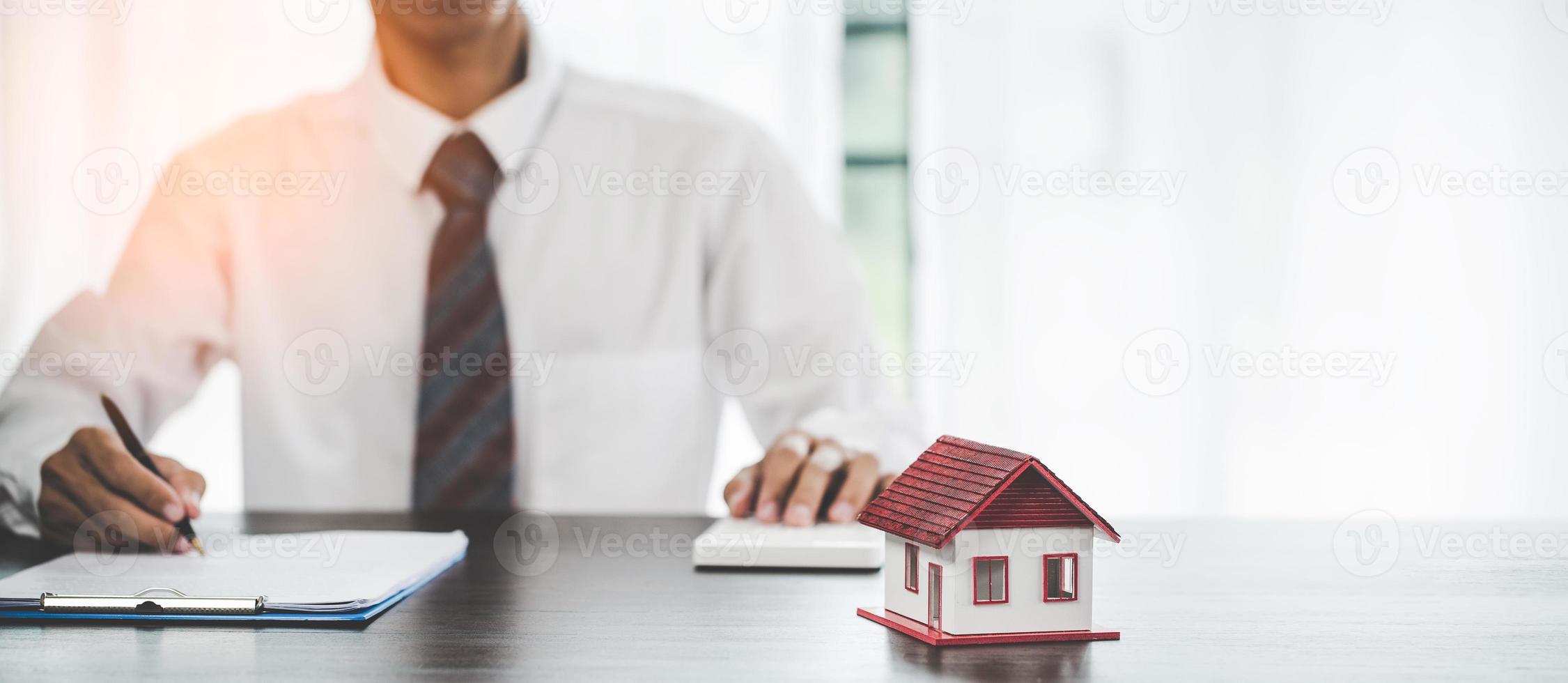 Real estate agents offer contracts to purchase or rent residential. Business person hands holding home model, small building red house. Mortgage property insurance moving home and real estate concept photo