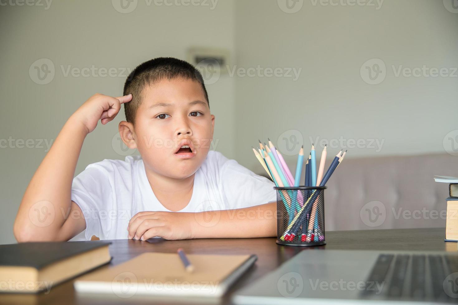 Young student distance learning virtual distance online class on video call virtual lesson, technology studying at home using laptop computer. Parent or tutor teaching child boy with remote education. photo