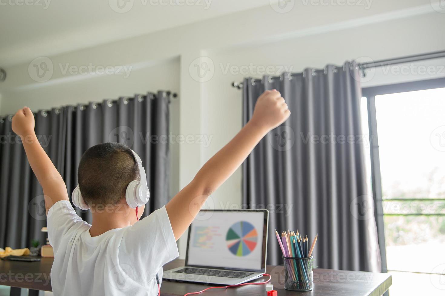Young student distance learning virtual distance online class on video call virtual lesson, technology studying at home using laptop computer. Parent or tutor teaching child boy with remote education. photo