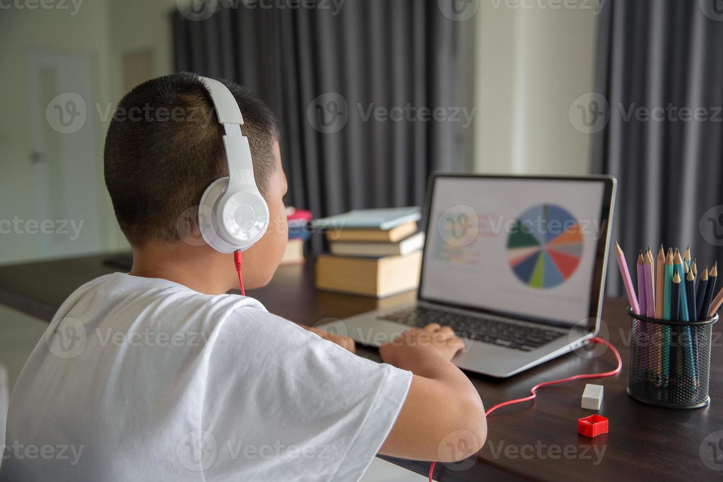 Young student distance learning virtual distance online class on video call virtual lesson, technology studying at home using laptop computer. Parent or tutor teaching child boy with remote education. photo