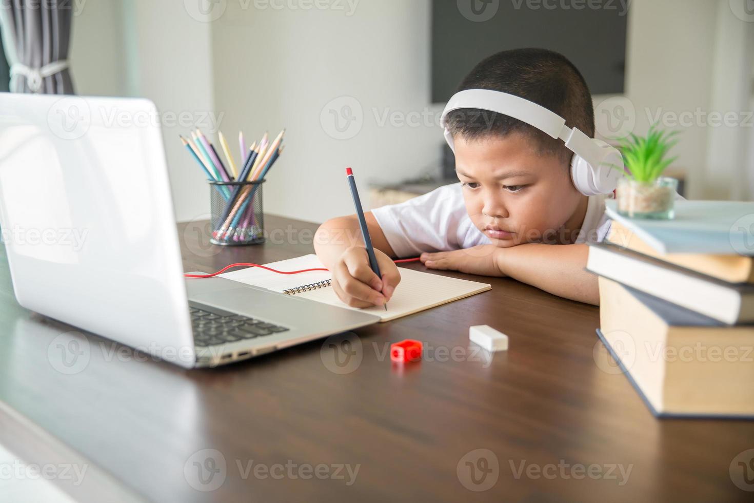 Young student distance learning virtual distance online class on video call virtual lesson, technology studying at home using laptop computer. Parent or tutor teaching child boy with remote education. photo