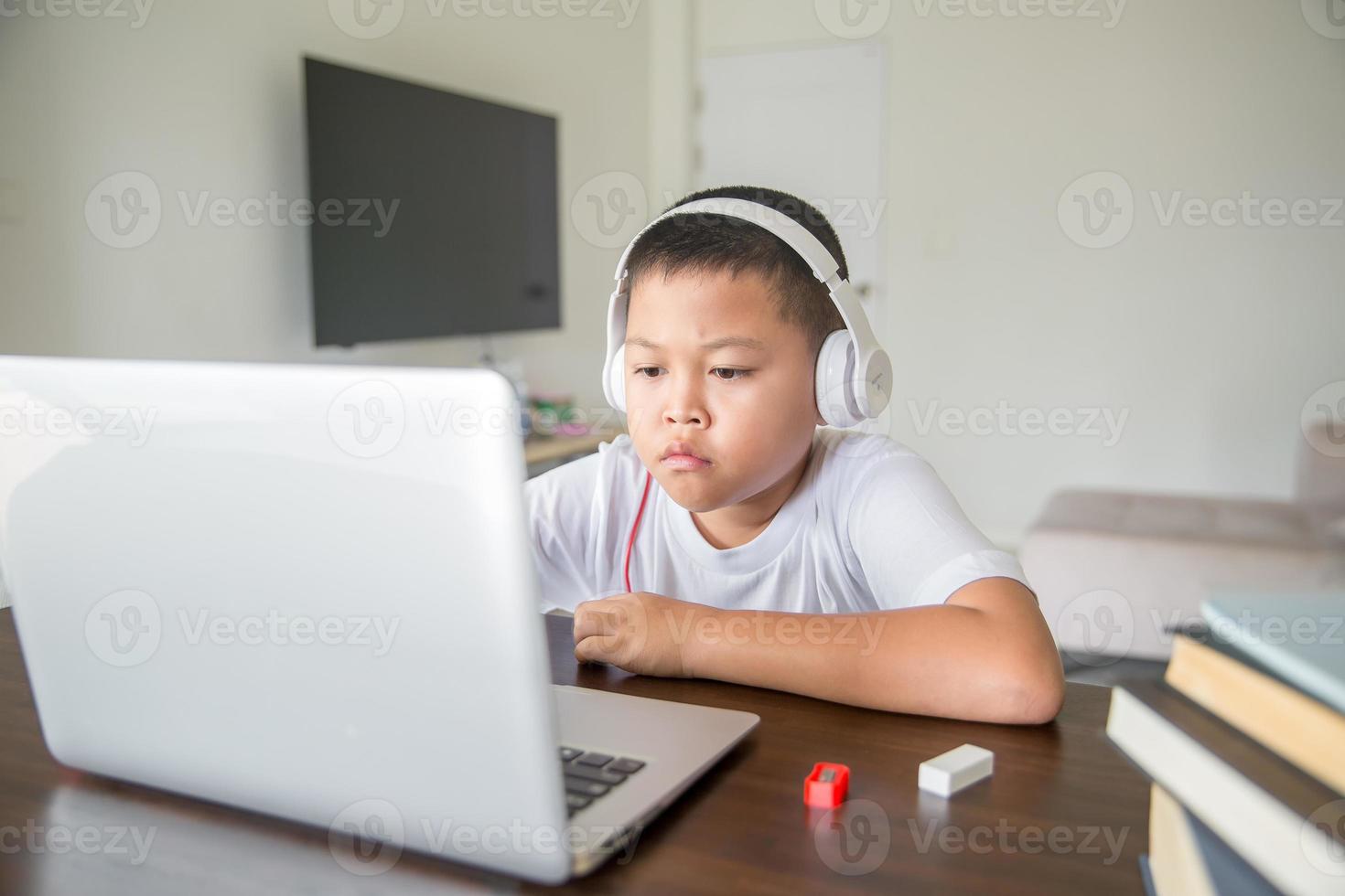 Young student distance learning virtual distance online class on video call virtual lesson, technology studying at home using laptop computer. Parent or tutor teaching child boy with remote education. photo