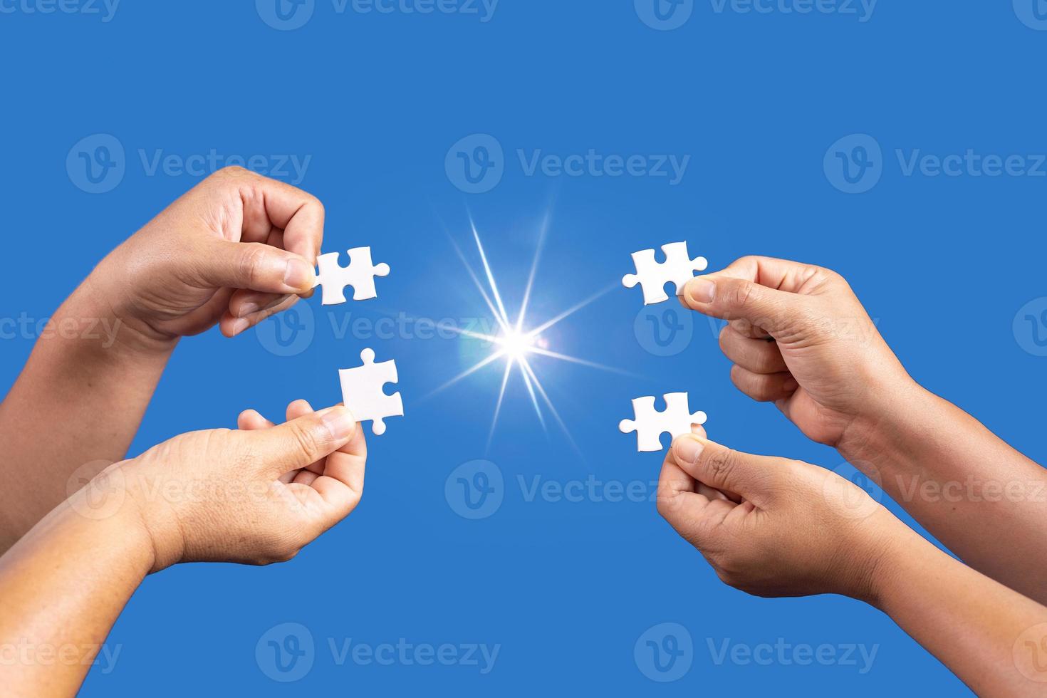 Hands holding jigsaw puzzles piece with clear blue background, success business, solution strategy, teamwork partnership concept photo