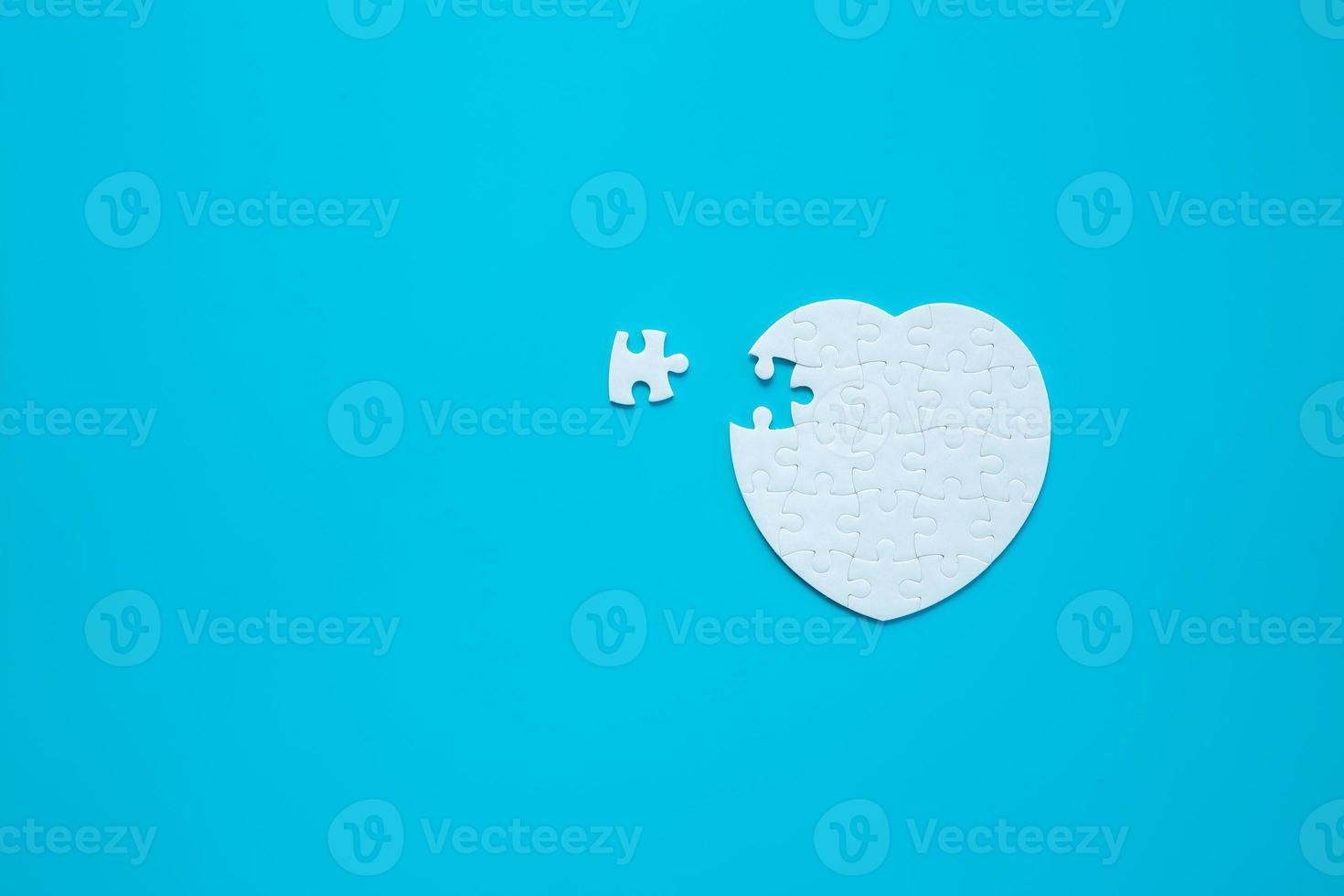 White heart shape of jigsaw puzzle pieces on blue background. concepts of problem solving, business success, teamwork, Team playing jigsaw game incomplete, Texture banner with copy space for text photo