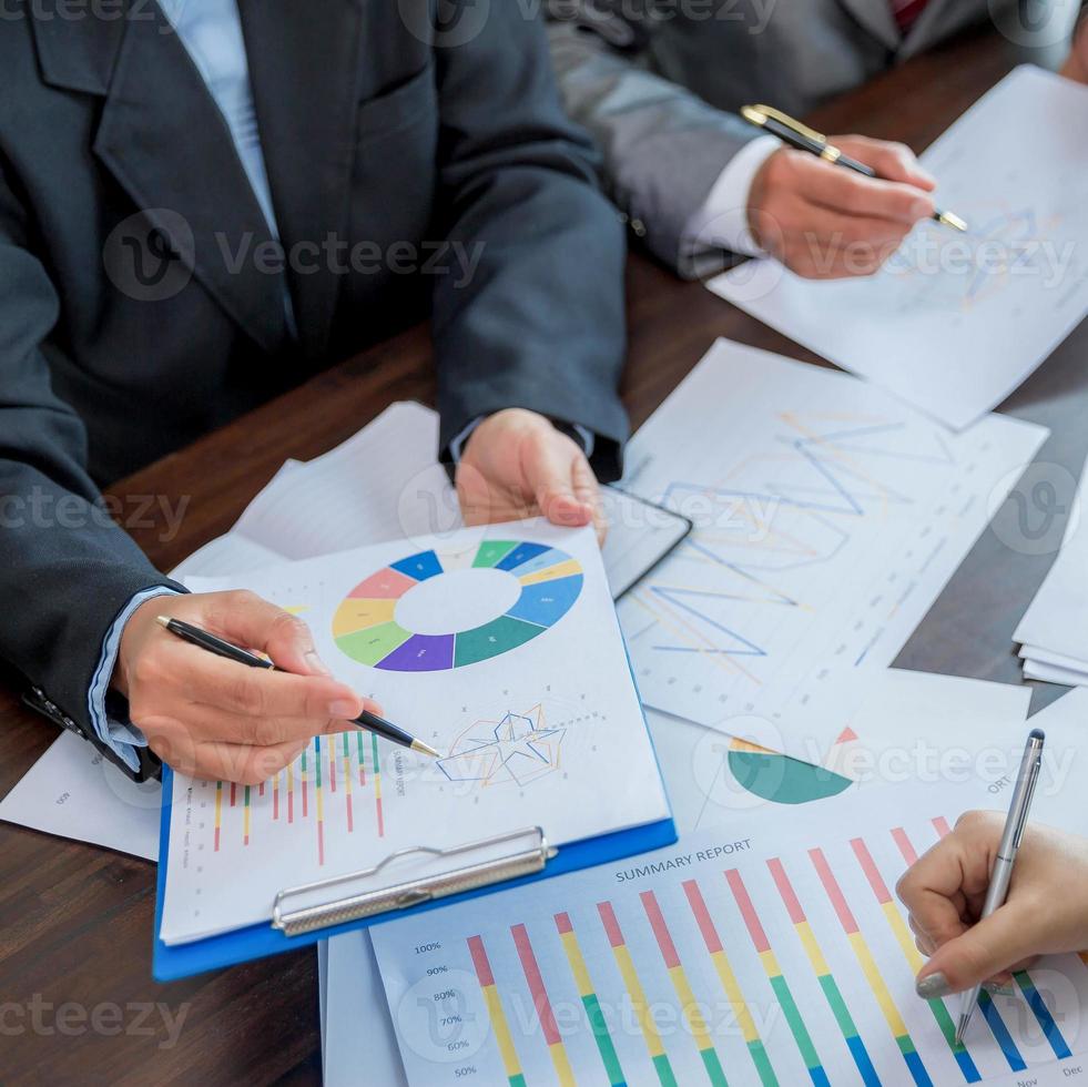 Group professional business people person working together to analyze in office, work together to discuss company financial statistics report, brainstorm ideas, and graph datum documents on the table. photo