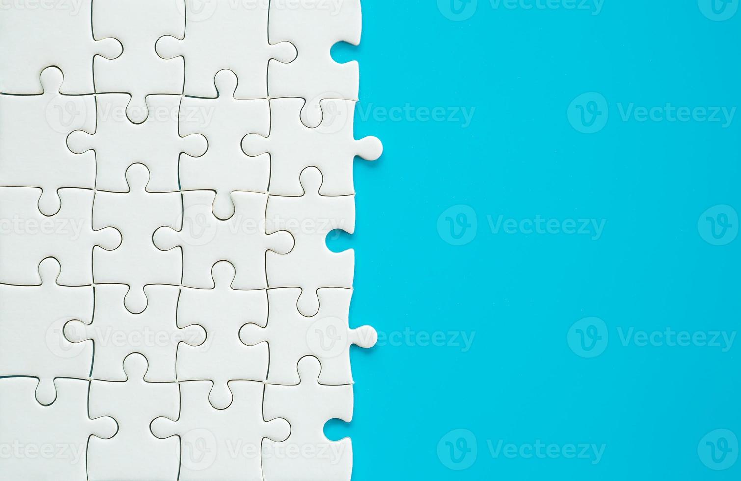 White part of jigsaw puzzle pieces on blue background. concepts of problem solving, business success, teamwork, Team playing jigsaw game incomplete, Texture photo with copy space for text