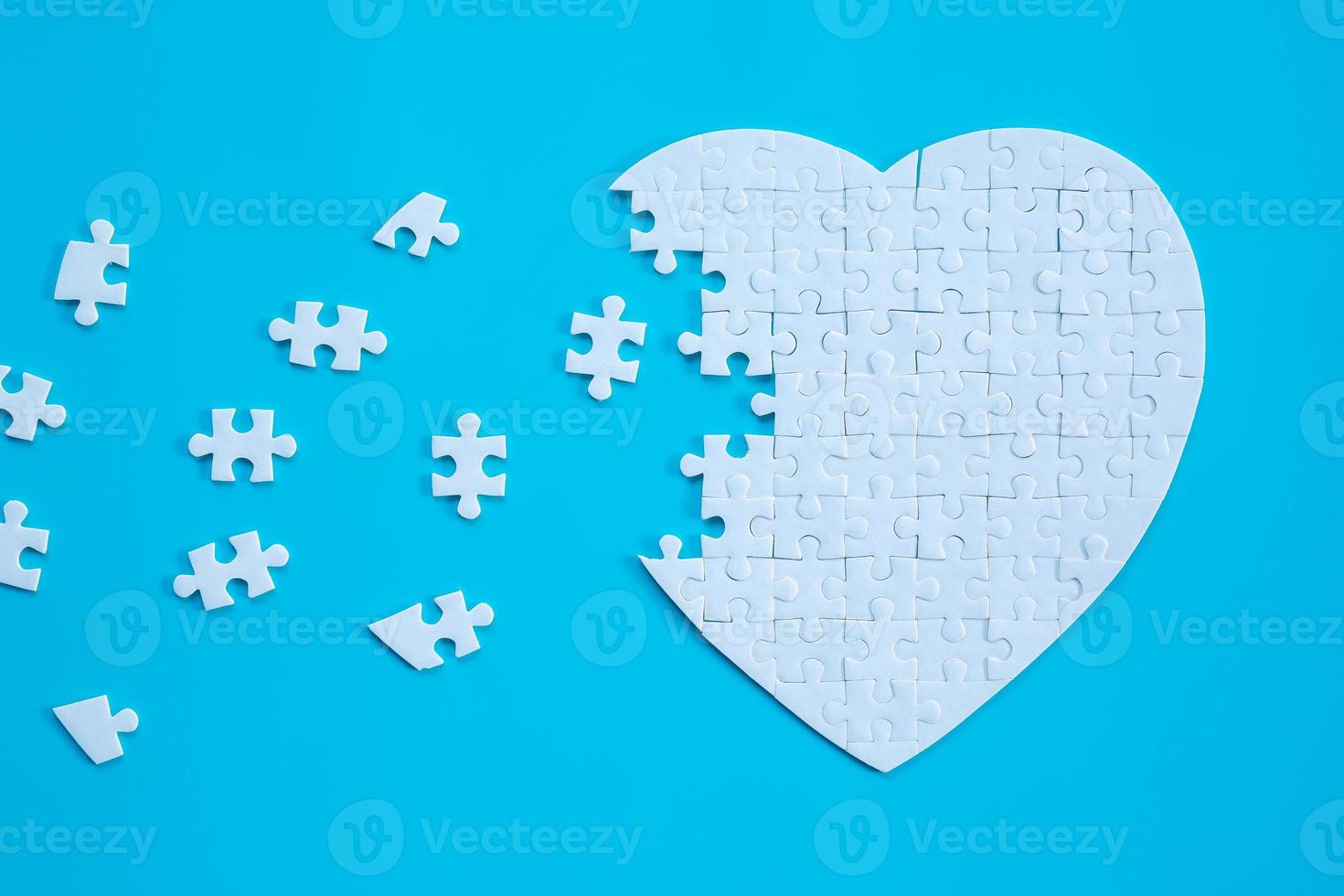 White heart shape of jigsaw puzzle pieces on blue background. concepts of problem solving, business success, teamwork, Team playing jigsaw game incomplete, Texture banner with copy space for text photo