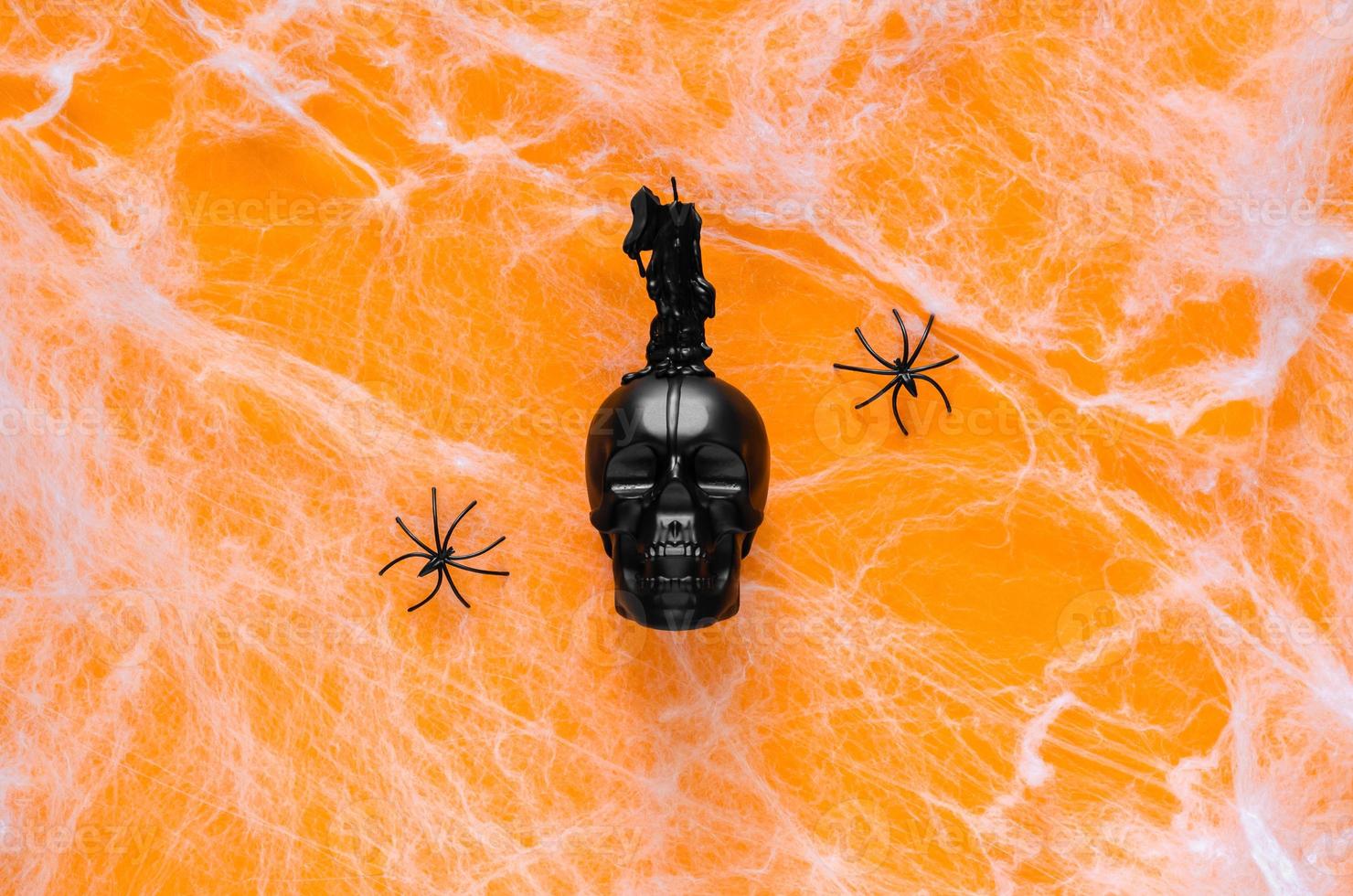 Scary halloween background with skull that have candle on top puts on orange background with spider and cobweb. photo