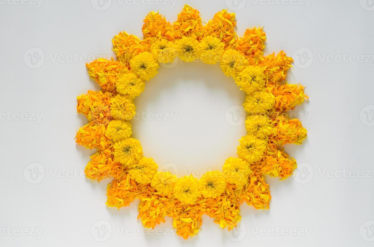 flores decorativas de caléndula de color amarillo y naranja y rangoli de pétalos para el festival de diwali con fondo de espacio en blanco. foto