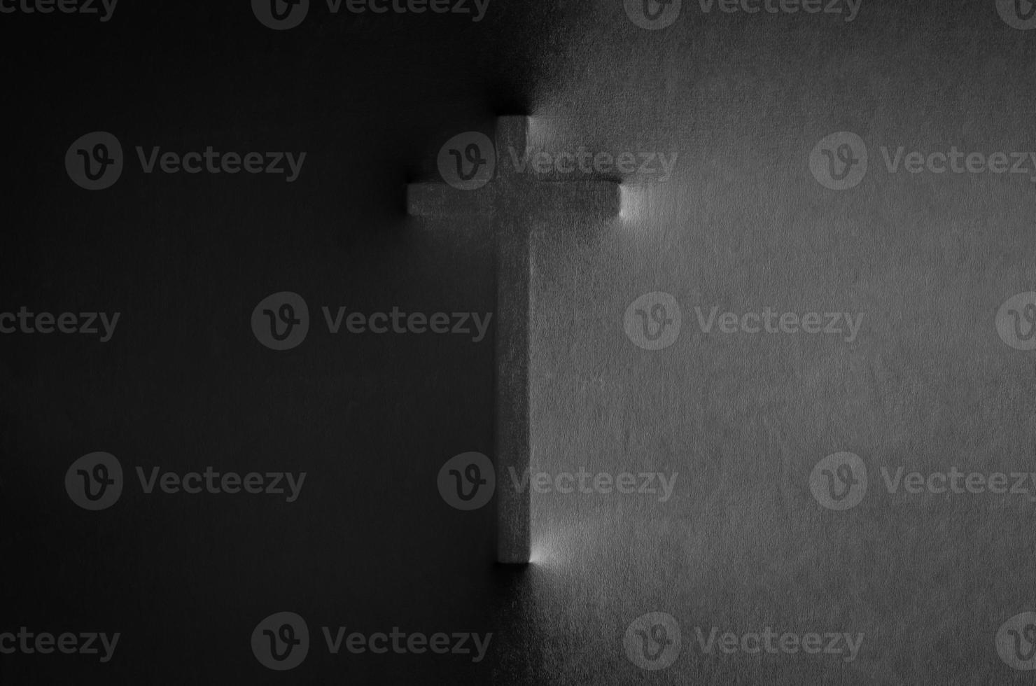 The cross pressing through black fabric with shine and dark side for Halloween background concept. photo