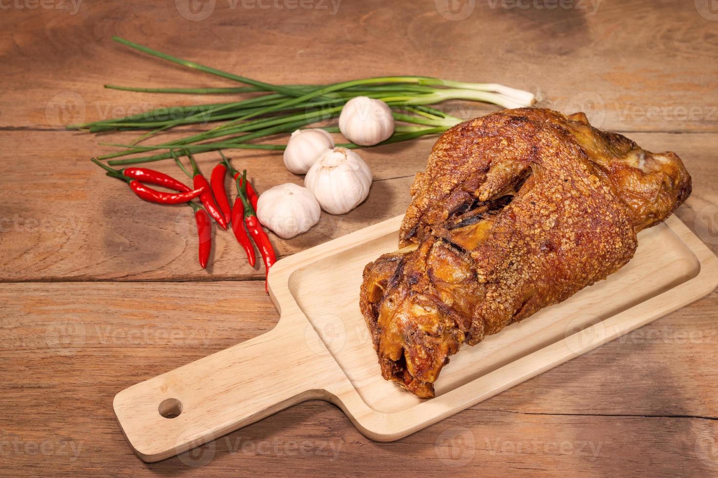fried pork leg cooked on chopping block photo