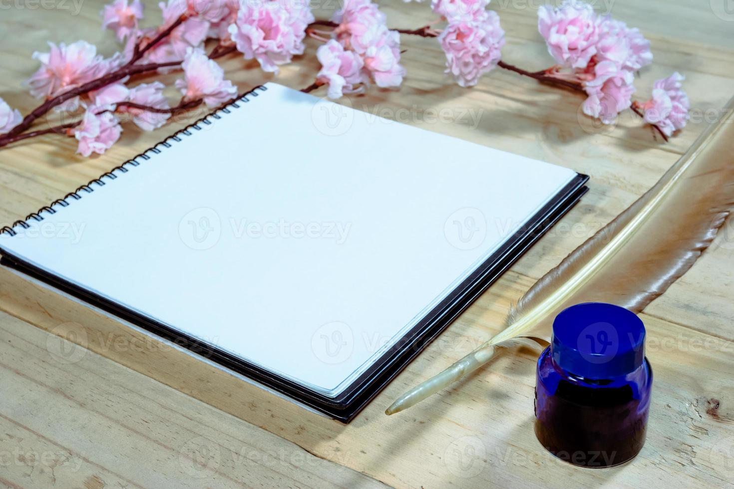 open note book with pink sakura flowers on wooden background,filter effect. photo