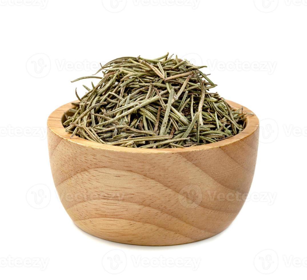 Dry rosemary in wooden bowl isolated on white background photo