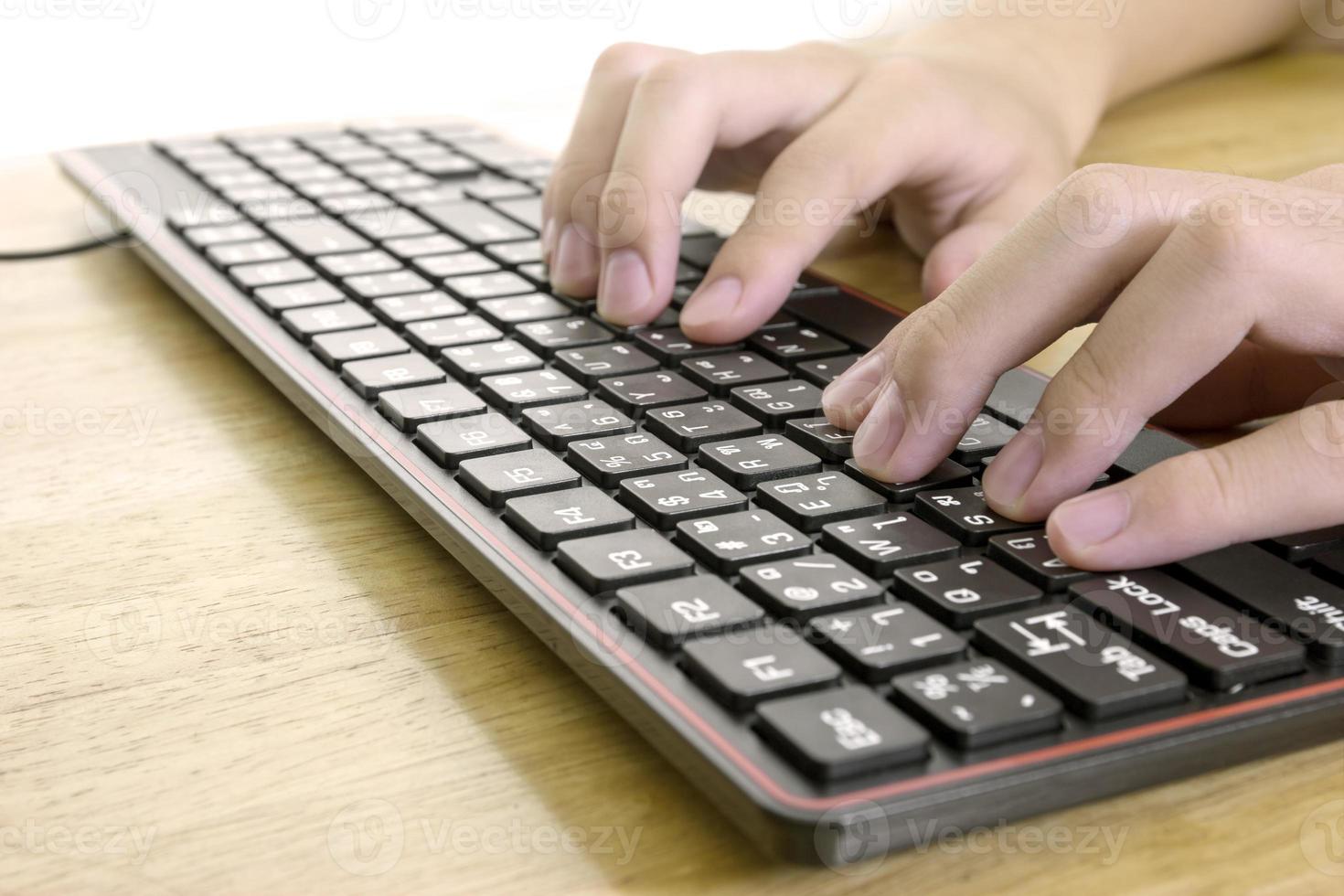 Close up of typing male hands on black keyboard,Businessman working concept,light effect photo