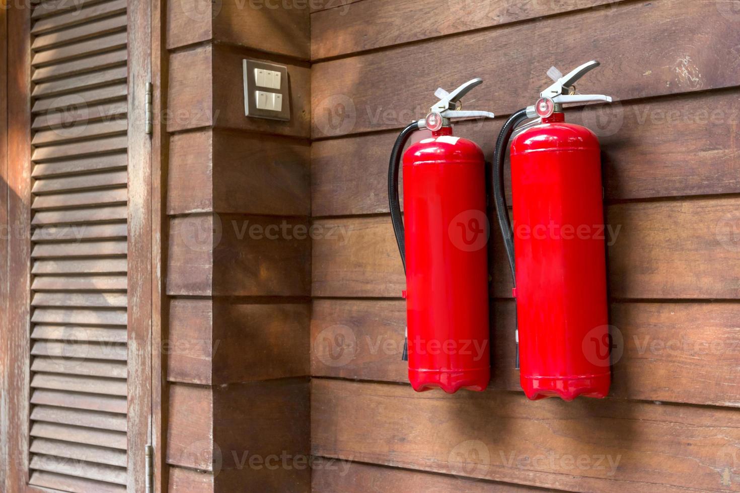 Fire extinguisher on wooden wall. photo