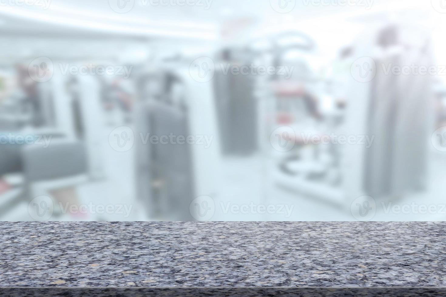 Marble table with blur fitness gym equipment background photo