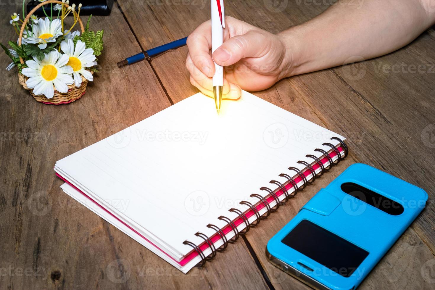 Light at the end of a pen on notebook photo