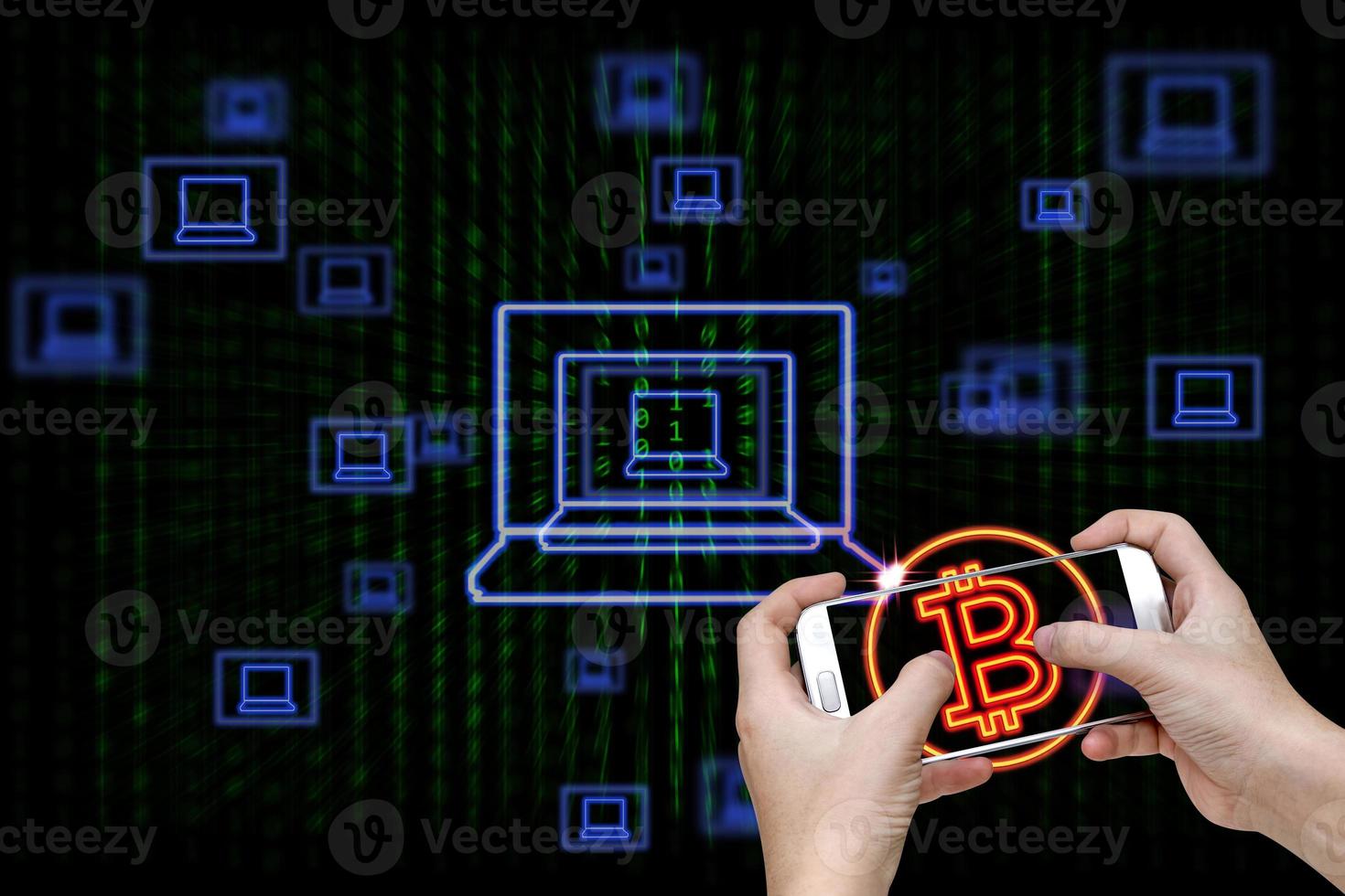 Human hand holding mobile smart phone with bitcoin symbol and laptop icons on binary background photo