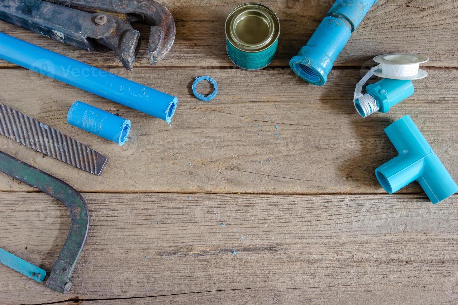 Plumbing tool pipes and equipment on wood background photo