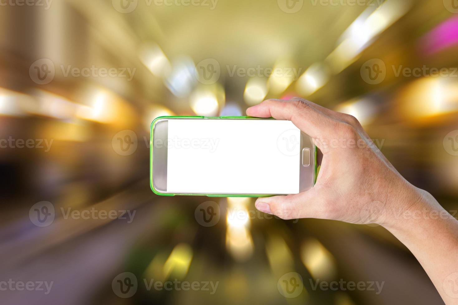 hand holding mobile smart phone with bokeh motion blur background photo