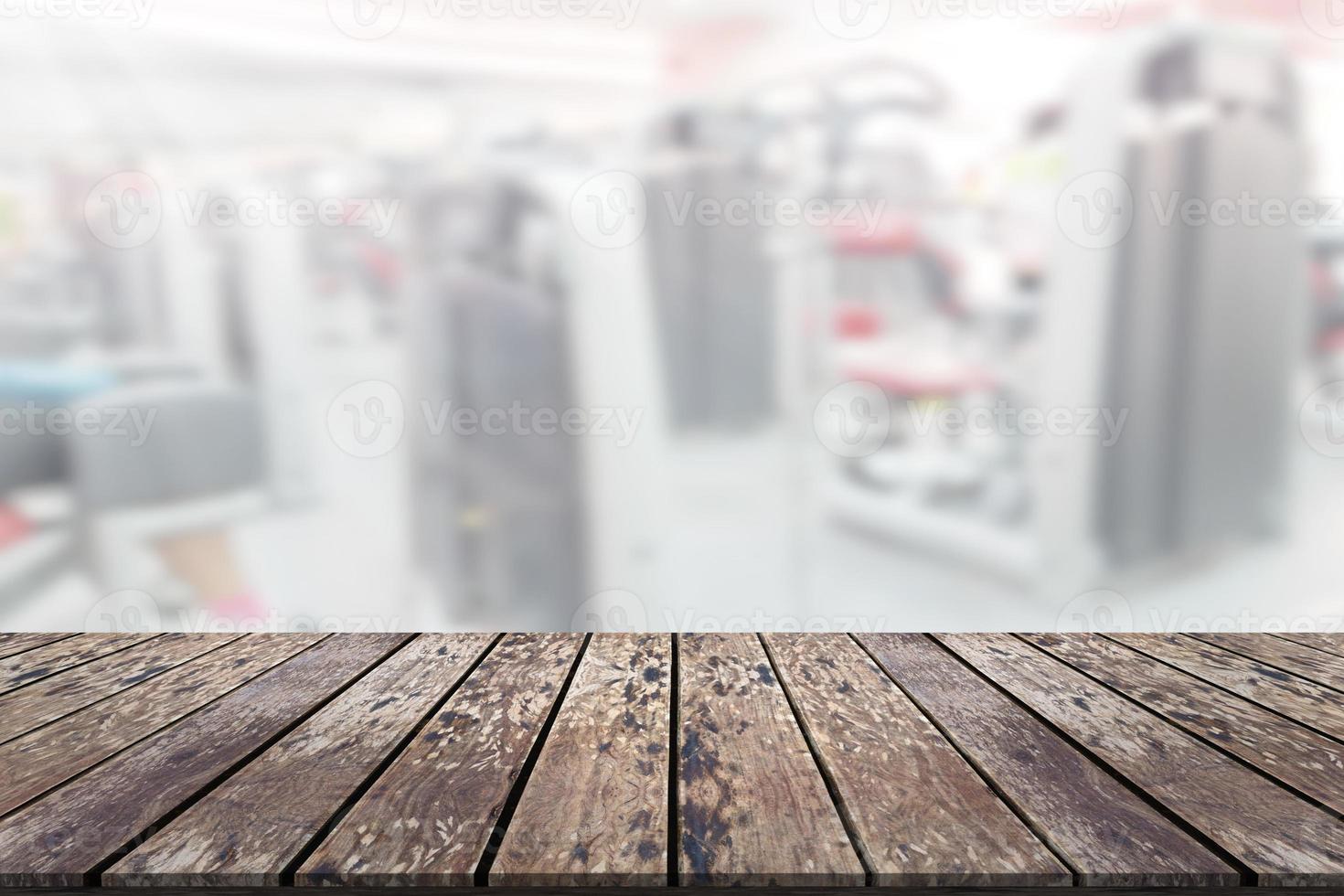 Empty wooden board space platform with blur fitness gym equipment background photo