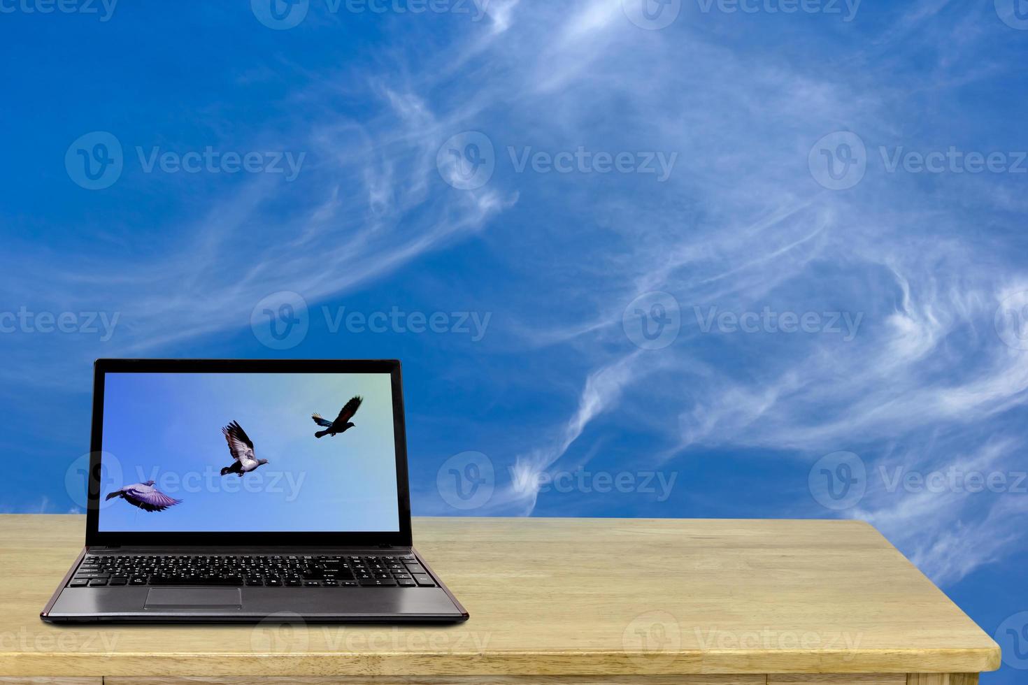 laptop on desk with sky background photo