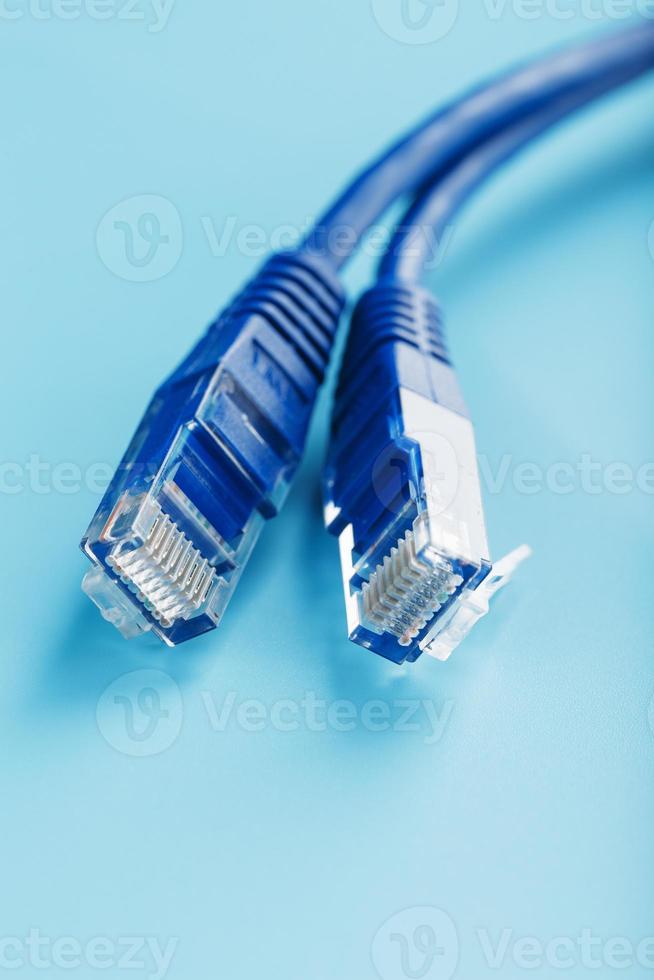 Two Ethernet Cable Connectors Patch cord cord close-up isolated on a blue background with free space photo