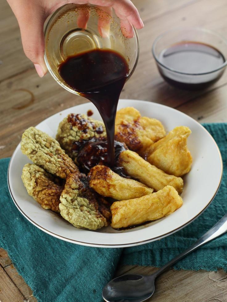 desenfoque de comida pempek empapada en salsa negra, comida indonesia foto