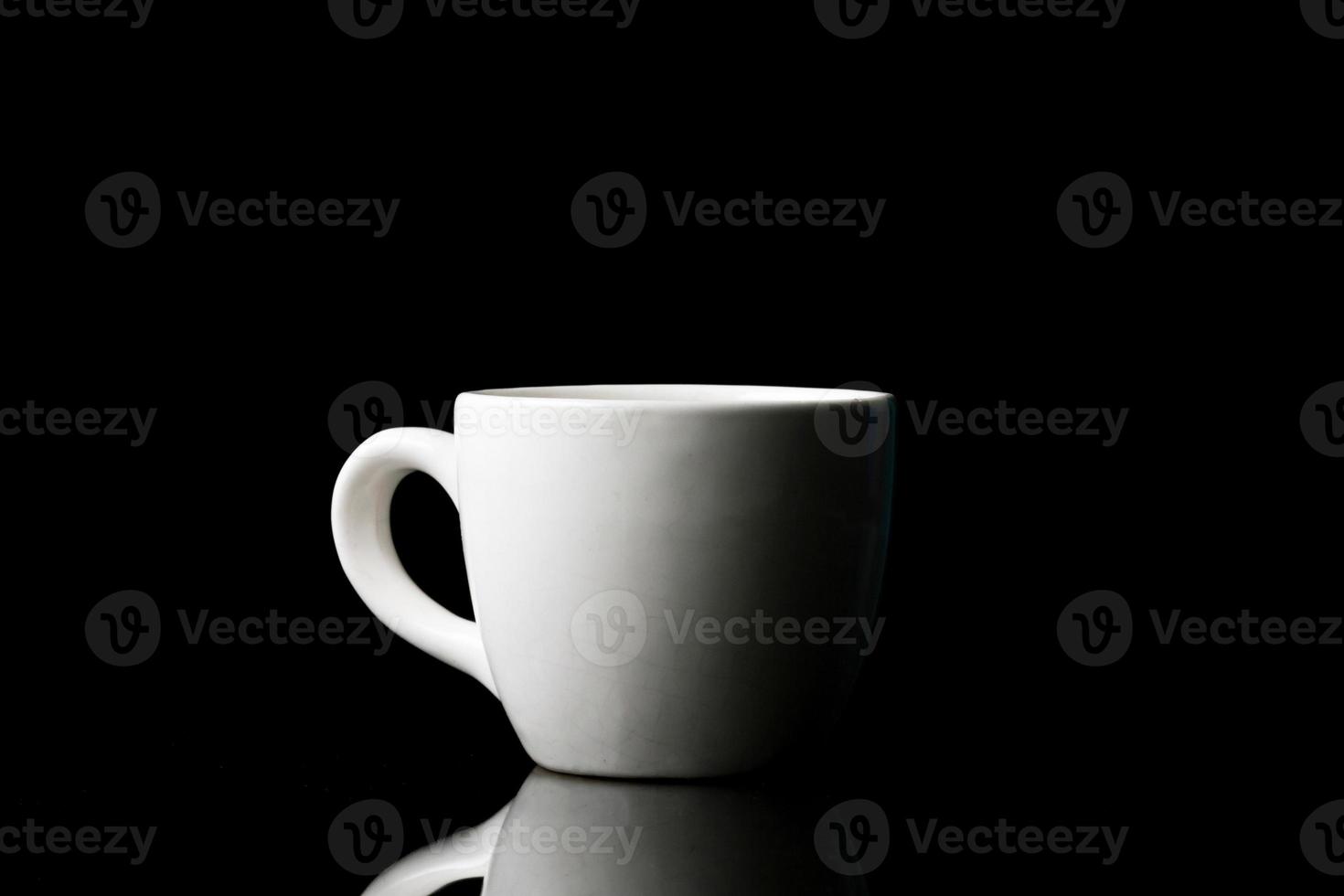 taza blanca sobre fondo negro. foto