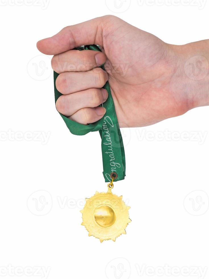 Hand holding Gold medal with green ribbon on white background photo