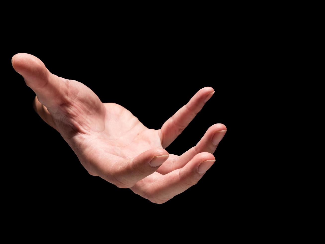 Male hand on a black background. photo