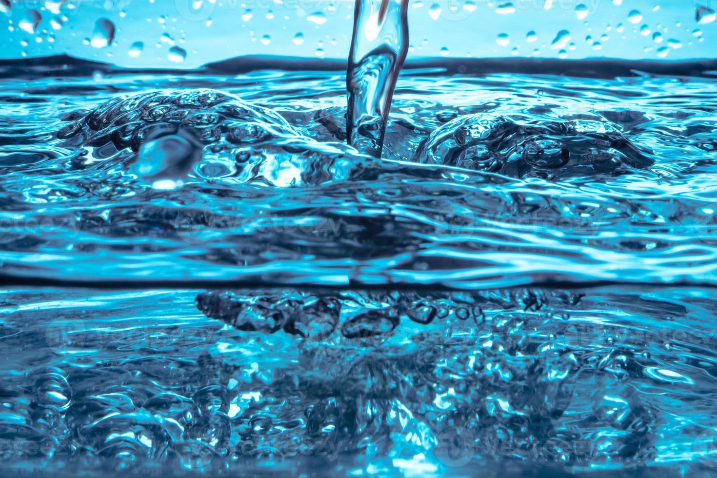 Close up of Pouring water on water surface background. photo