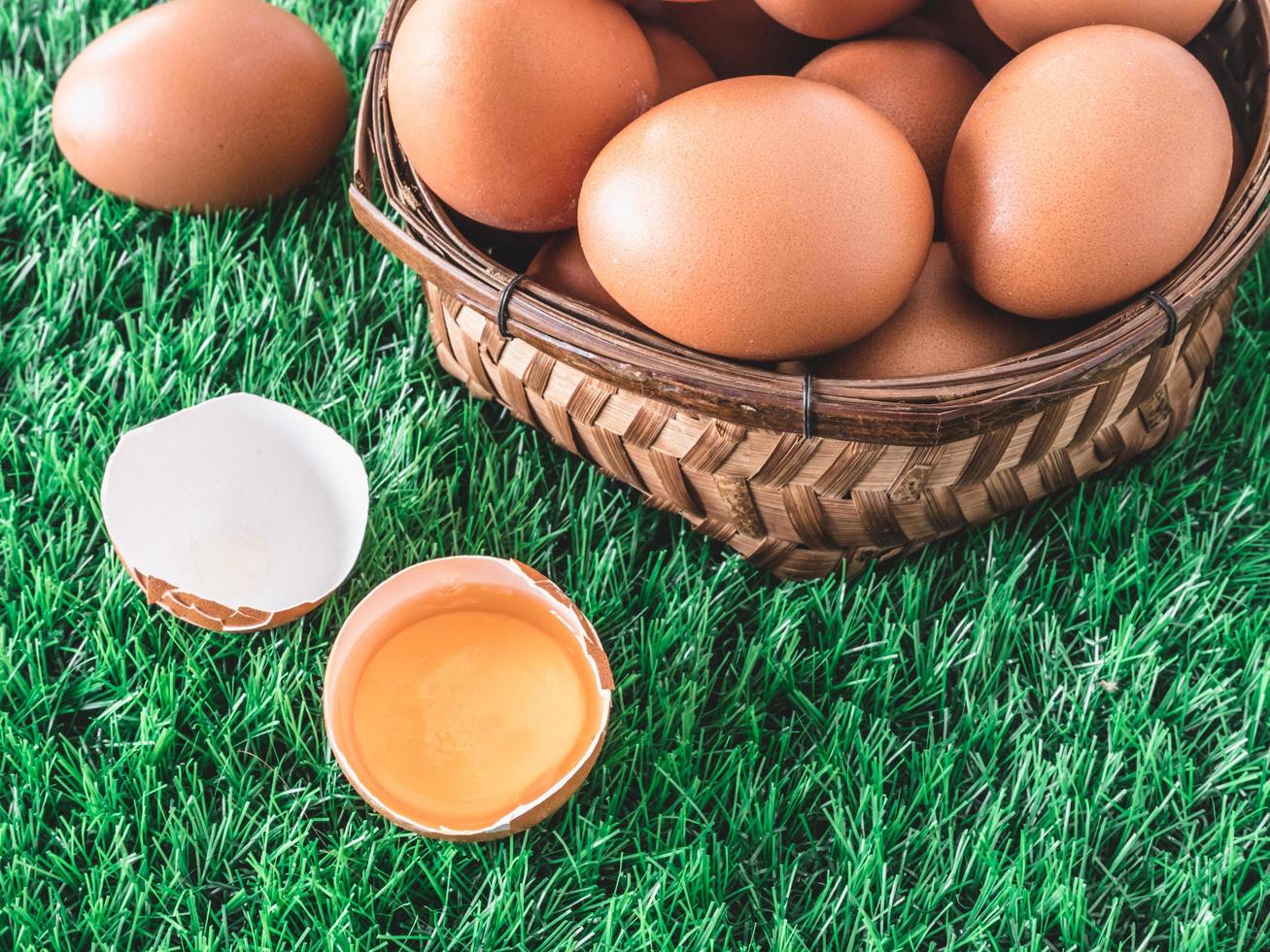 Eggs in wooden basket on green grass. Selective focus photo