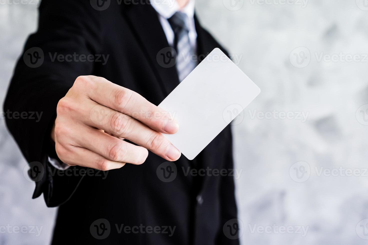 Close up of businessman holding white blank card on grunge background. photo