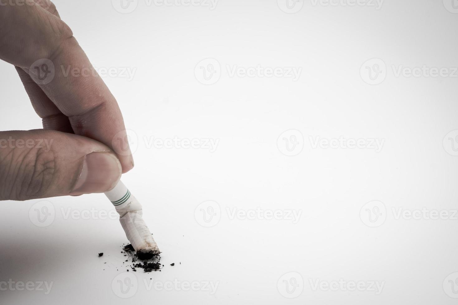 A hand push the cigarette stub on white background, Symbolic stop smoking concept, Free space for text photo