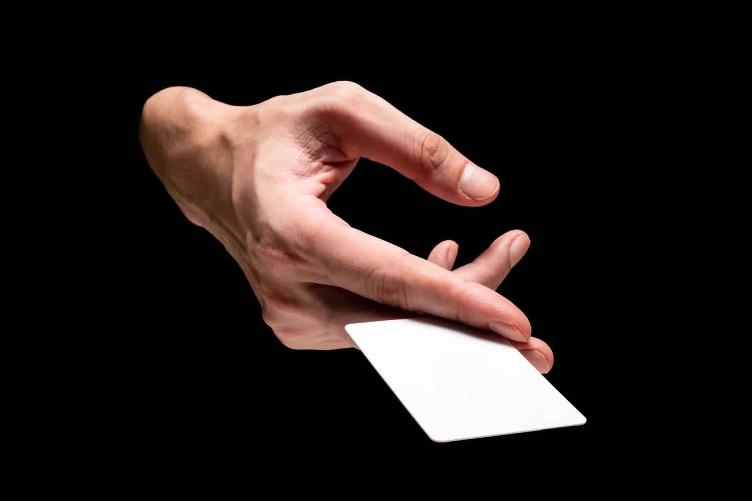 mano masculina sosteniendo la tarjeta sobre un fondo negro. foto