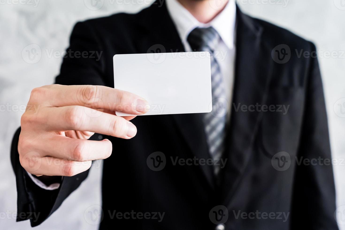 Close up of businessman holding white blank card on grunge background. photo