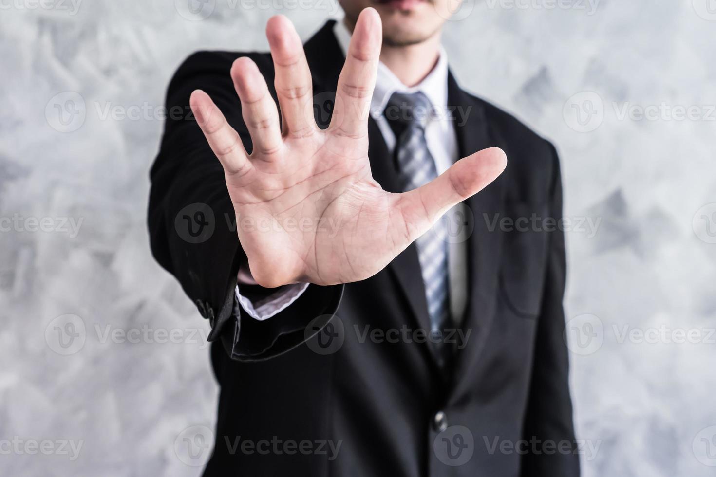 Close up of businessman showing palm handsign on grunge background. photo