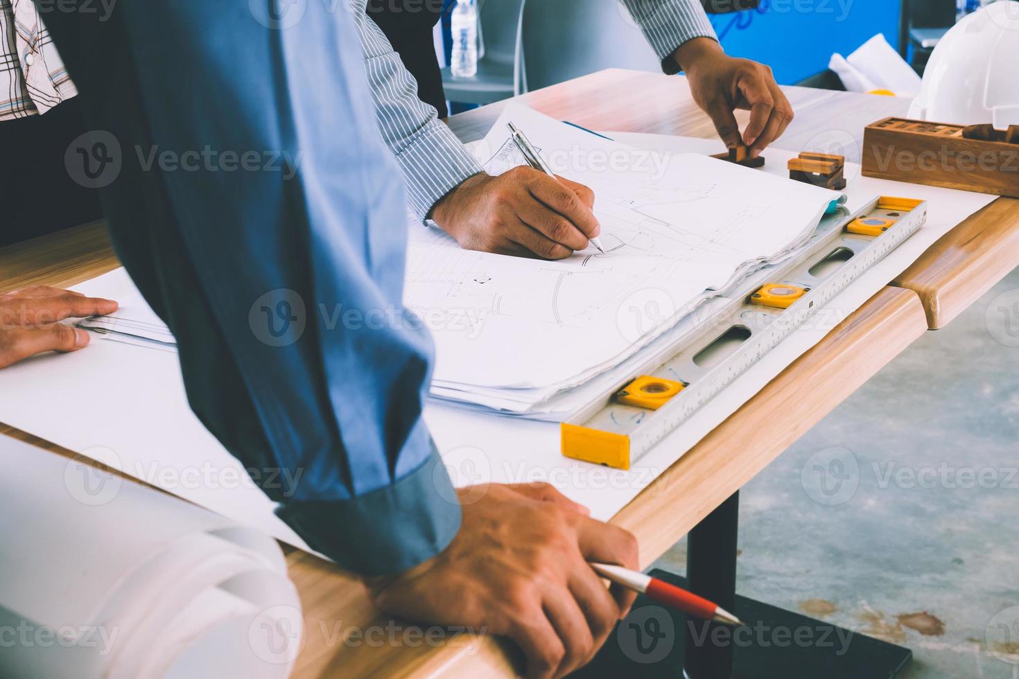 Team of engineers discussing architecture plan sketch at the construction site. photo