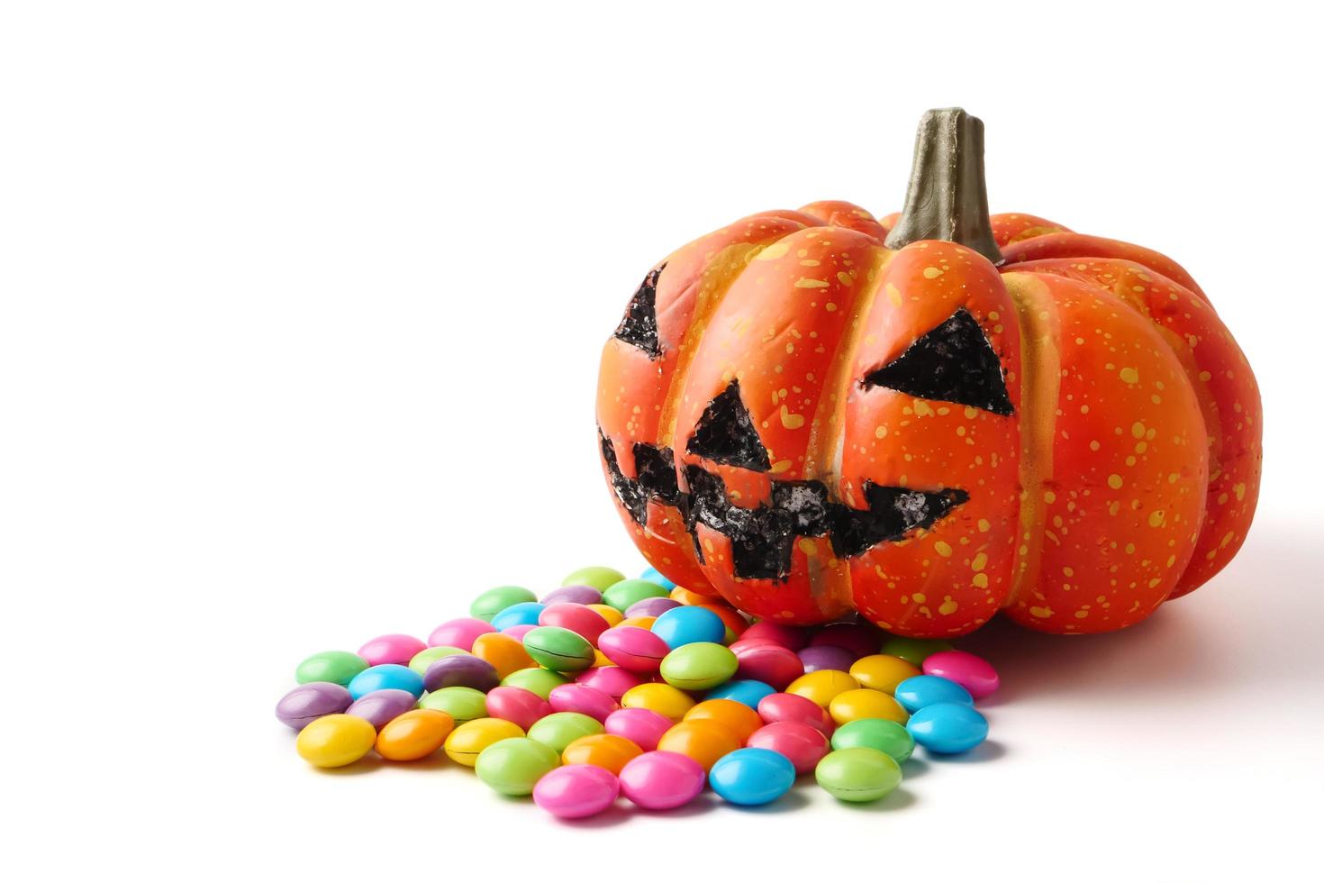 calabaza de Halloween con un montón de dulces sobre un fondo blanco. foto