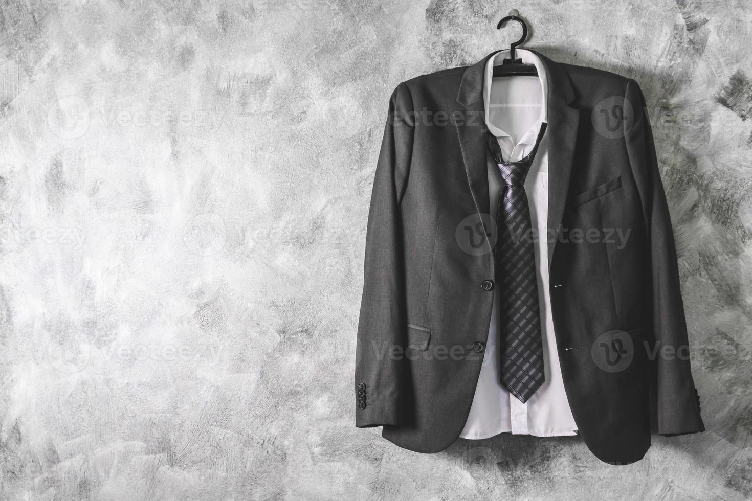 Gray suit and tie and white shirt on grunge background. Free space for text photo