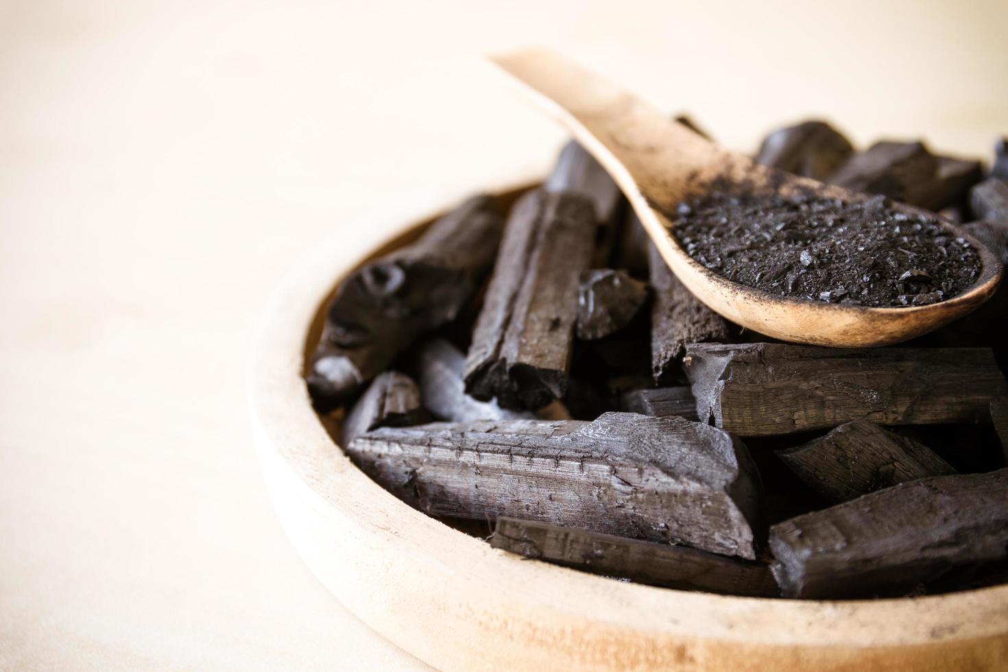 Charcoal and charcoal powder on wooden spoon. Selective focus photo