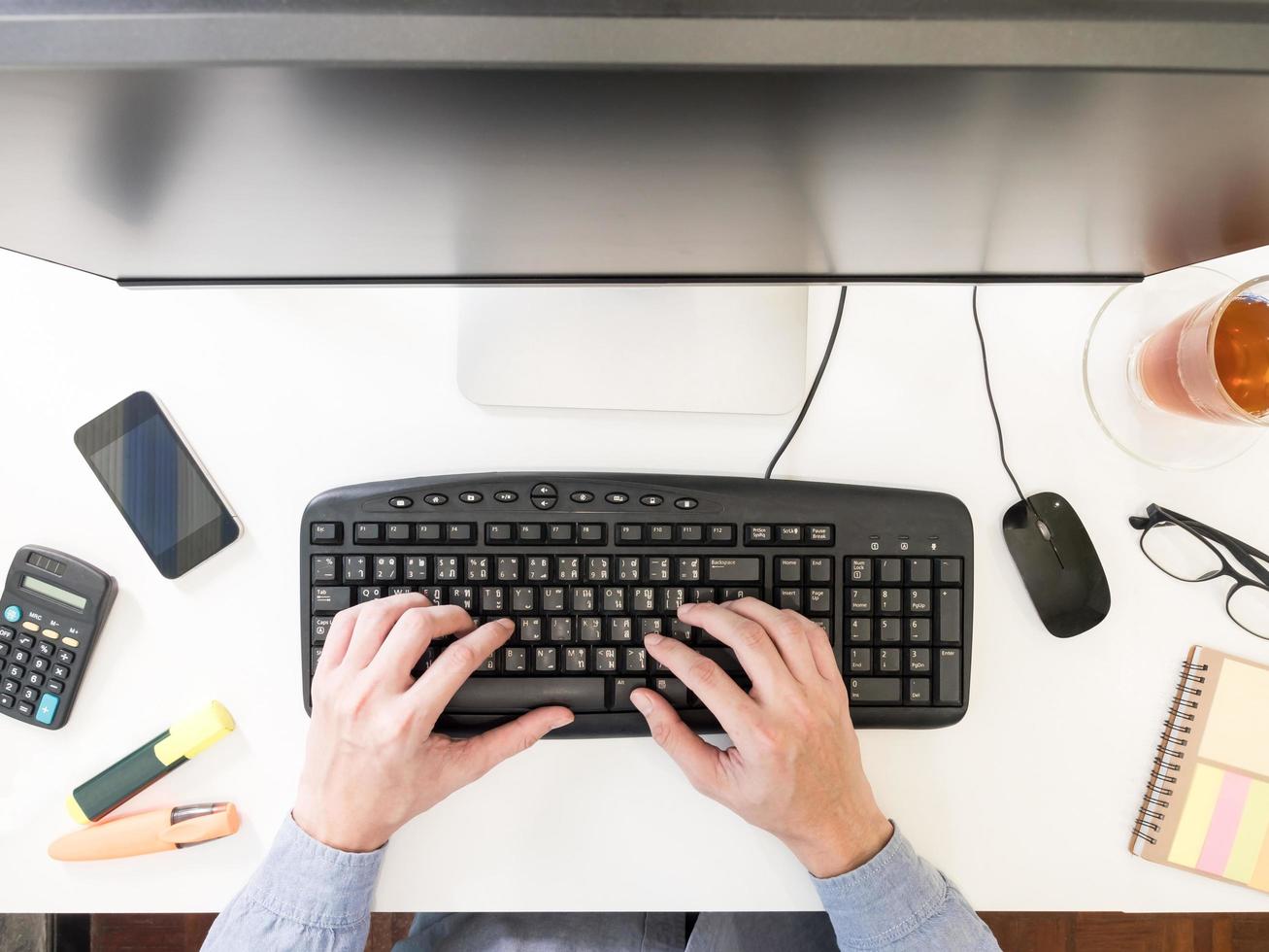 Top view of male hands working on computer on the desk. photo