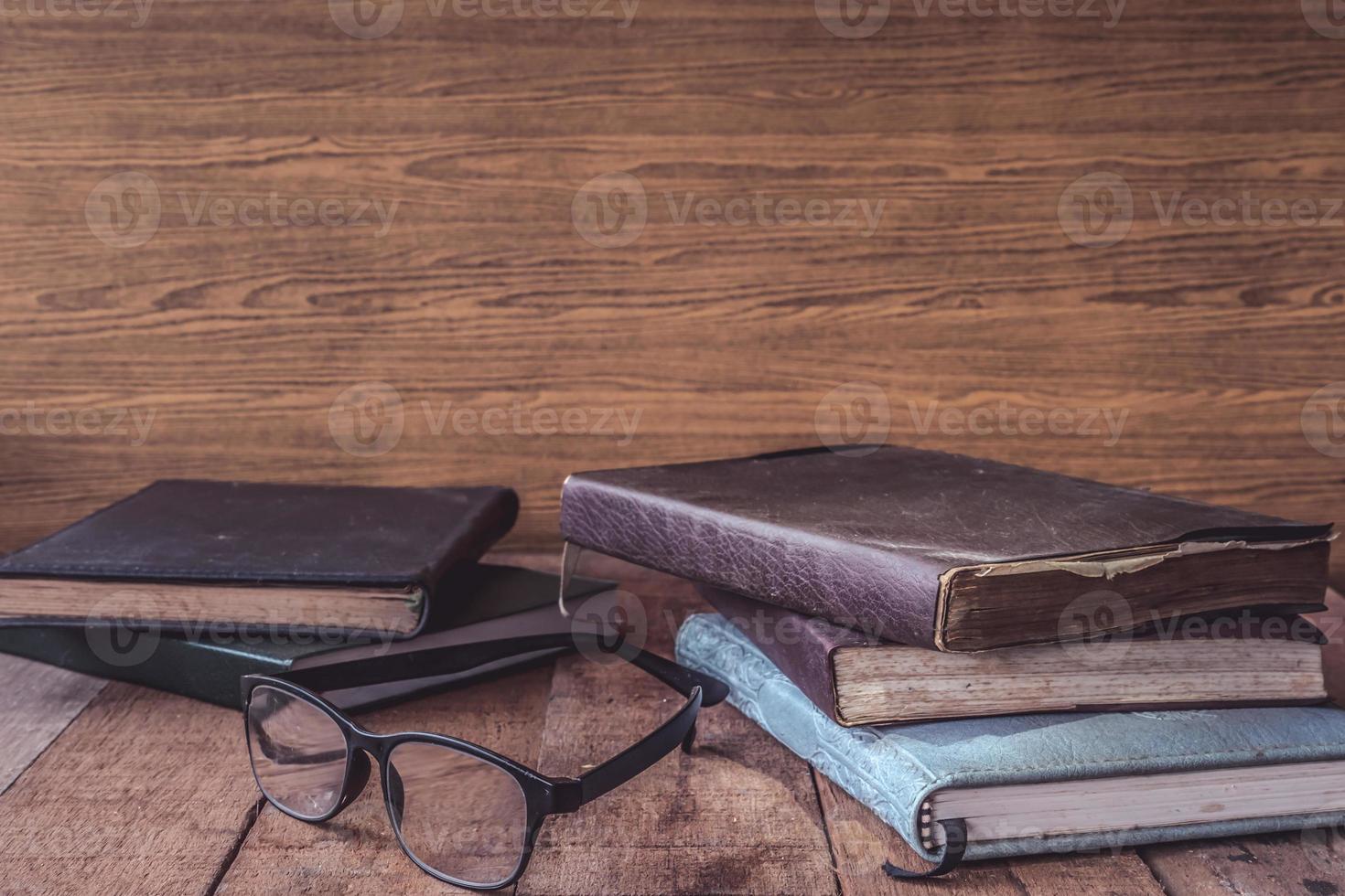 Old books with glasses on wooden table. Free space for text photo